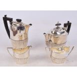 A George V hallmarked silver four piece tea set comprising teapot of oval form with gadrooned