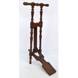 An early 20th century oak boot jack with turned supports and bearing plaque inscribed "Peal & Co