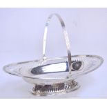 An Edward VII hallmarked silver oval pierced basket with swing handle raised on oval pierced