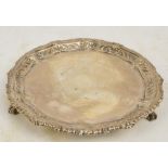 An Edward VII hallmarked silver circular salver with raised floral cast and embossed rim,