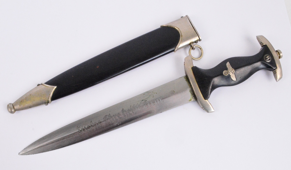 A period German Third Reich SS dagger with twin emblems to the wooden handle and blade inscribed