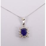 A 9ct white gold fine link chain supporting a 9ct white gold, sapphire and diamond pendant,