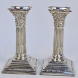 A pair of Edward VII hallmarked silver candlesticks modelled as Corinthian columns on square