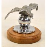 A Desmo car mascot modelled as an eagle upon a spear with radiator screw cap cover attached,