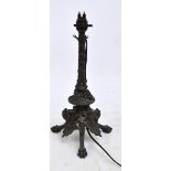 A late 19th century bronze table lamp with turned central column above triple mask set platform,