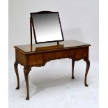 A 1920s walnut and inlaid kneehole dressing table with glazed top above a central frieze drawer