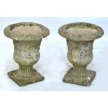A pair of composite stone small urns decorated with animal masks with horns, height 46cm.