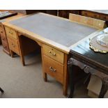 A mid 20th century oak desk with leather top and two brass handled drawers either side of a