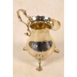 An Edward VII hallmarked silver cream jug of baluster form with shaped rim,