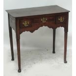 An early 19th century oak and red walnut lowboy with rounded rectangular top above three frieze