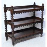 A Victorian oak Gothic style three tiered buffet with shaped apron,