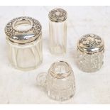 Four hallmarked silver mounted clear cut glass dressing table jars including a hair tidy,