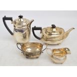 A George V hallmarked silver four piece tea set comprising a teapot of oval form with fluted