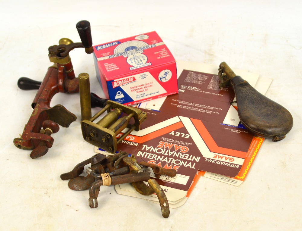 A collection of shooting related items including a combination rollover tool, a leather shot flask,
