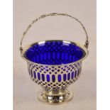A George V hallmarked silver circular footed basket with geometric pierced work to sides and bead