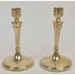 A pair of Edward VII hallmarked silver candlesticks with loaded bases and tapering knopped stems