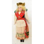 An early 20th century small bisque headed doll in national costume, height 36cm.