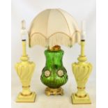 A green glass globular lamp base with applied floral motifs on a gilded stand with a fringed and