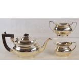 A George V hallmarked silver three piece tea set of bulbous form raised on oval foot,