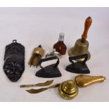 A copper powder flask, a set of brass stacking weights, two flat irons, a bell, a pair of pliers,