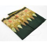 A green baize fringed front piece embroidered, with stylised leaves and shapes, some gold thread,