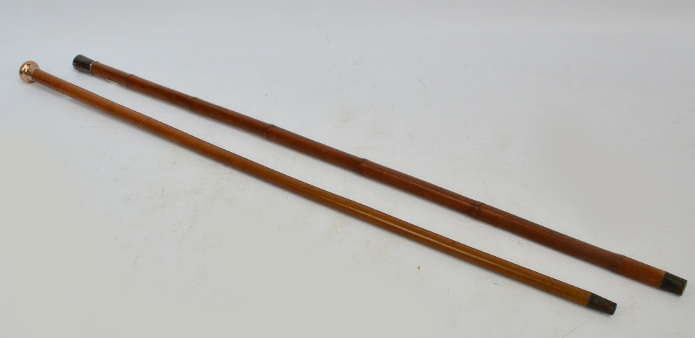 A white metal topped walking cane with bamboo shaft,