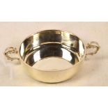 A George V hallmarked silver butter dish of plain circular form, with twin C-scroll handles,