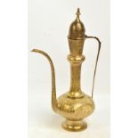 An eastern tall polished brass jug/ewer with domed lid, knopped neck and high spout and handle,