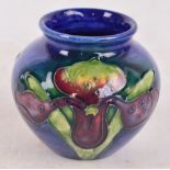 A small Moorcroft vase decorated in the Orchid pattern, impressed marks to base, height 7cm.