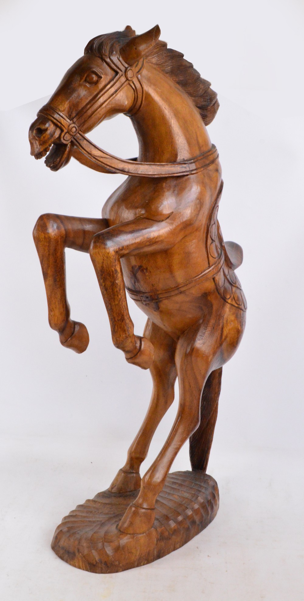 A large decorative carved oak figure of a rearing horse on oval base, height 100cm.