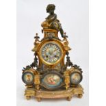 A late 19th century French gilt metal and porcelain eight day mantel clock surmounted with a