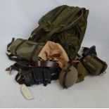 An army backpack, a camouflage ground sheet, belt with flask attachments, various other belts, etc.