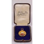 A 9ct yellow gold circular medal with enamel decorated coat of arms,