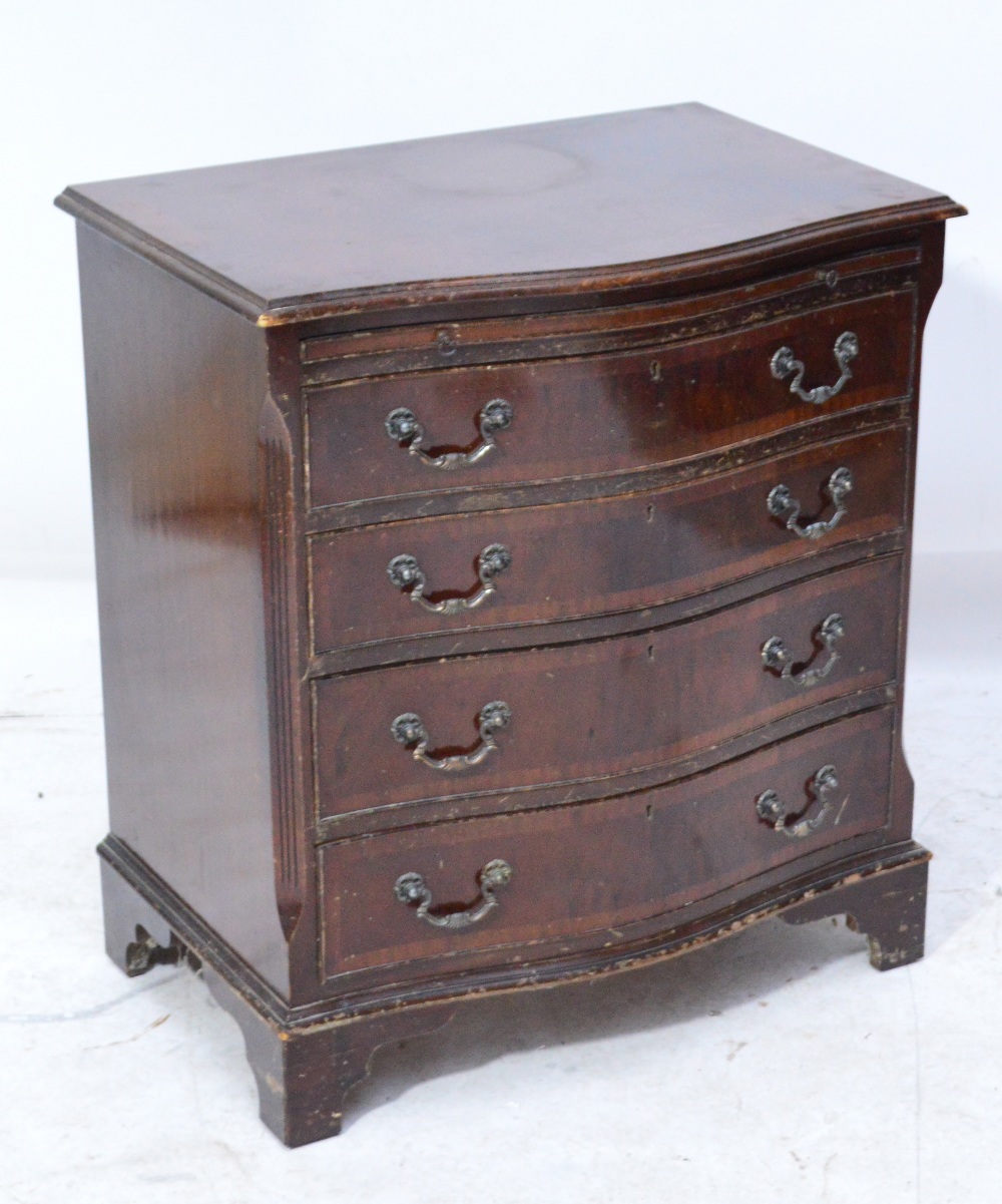 A serpentine mahogany chest of drawers of small proportions,