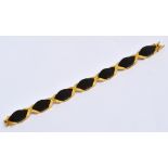 A 1970s textured yellow gold and black onyx set bracelet,