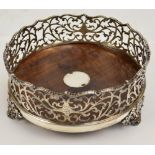 A Victorian hallmarked silver mounted and rosewood bottle coaster of circular form with pierced