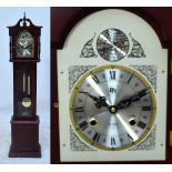 A reproduction grandmother clock with glazed door showing two brass weights on a plinth base,