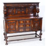 An early 20th century oak side table with carved back, urn shaped supports,