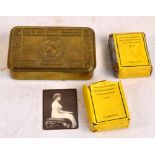 A WWI Queen Mary Christmas tin containing a part smoked pack of cigarettes and an open pack of