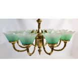 An eight branch brass electrolier with flower shaped drip trays,