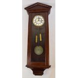 An early 20th century oak cased eight day double weight driven wall clock with arched pediment
