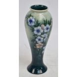 A William John Moorcroft vase of baluster form tube line decorated with blue flowers on two tone