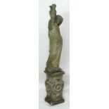 A composite stone statue of a naked lady bathing, set on a plinth decorated with ivy leaves,