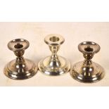 A pair of Edward VII hallmarked silver candlesticks with bell shaped sconces,