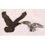 A German metal spread eagle insignia, width 19cm, and a further insignia of an eagle,