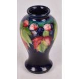 A small Moorcroft vase of baluster form with tubeline decoration in the "Leaf and Berry" pattern,