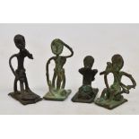 A set of four North African metal weights in the form of figures performing domestic and