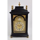 A late 18th century Dutch ebonised bracket clock with brass finials above arched dial inscribed