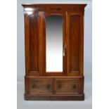 A Victorian mahogany wardrobe with central mirrored door enclosing interior with hooks and hanging
