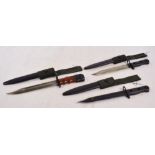 Three short bayonets with metal scabbards and canvas loops.